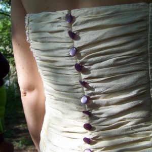 Robe de mariée en doupion de soie ivoire, ouverte sur jupon en organza de soie violet, ornée de dentelle violette (détail dos)