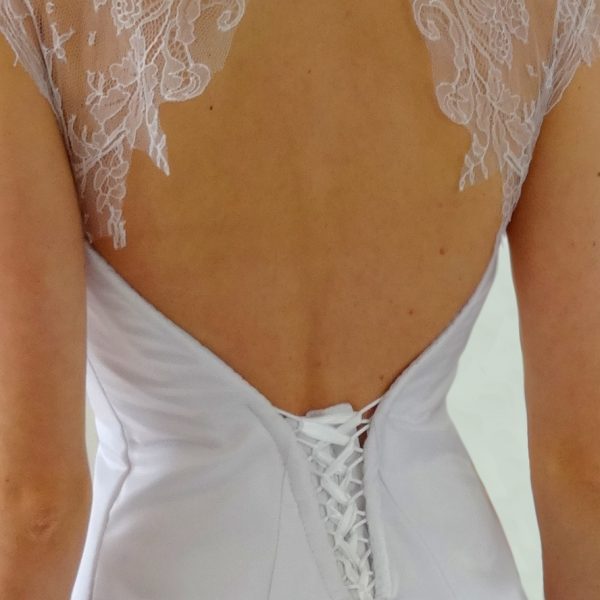 Robe de mariée en satin blanc, ornée de dentelle de Chantilly, avec grande traîne (détail dos)
